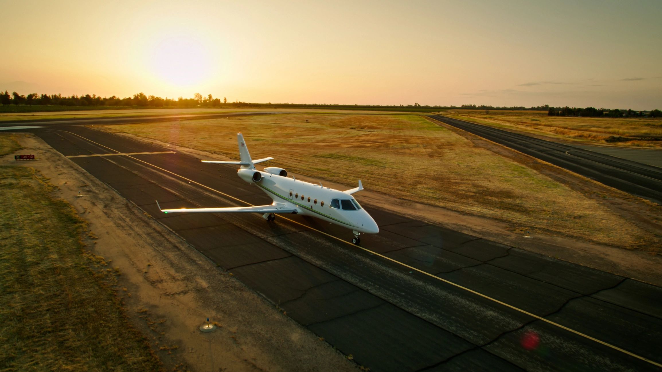 Sunset behind a private jet on the tarmac